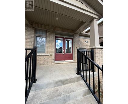 A house with a red door and a black railing.