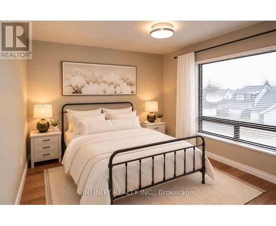 A bedroom with a large bed, two nightstands, and a window with blinds.