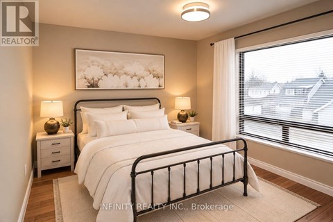 A bedroom with a large bed, two nightstands, and a window with blinds.