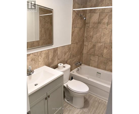 A bathroom with a toilet, sink, and bathtub.