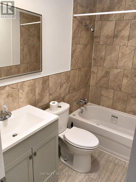 A bathroom with a toilet, sink, and bathtub.