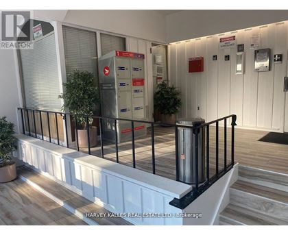 A real estate office with a black railing and a red mailbox.