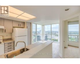 A kitchen with white appliances and a view of the city.
