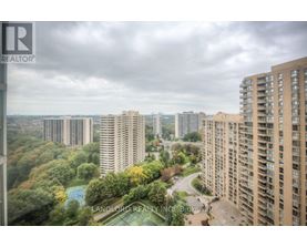 A view of a cityscape from a high-rise building with a pool in the foreground.