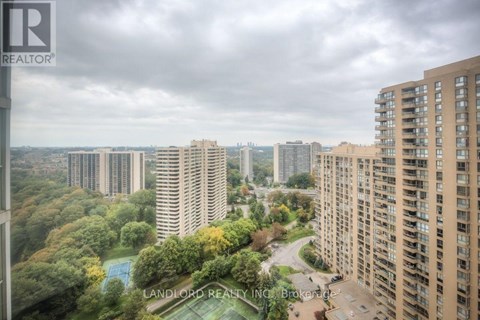 A view of a cityscape from a high-rise building with a pool in the foreground.