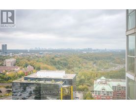 A view from a high-rise building looking out over a cityscape with a mix of residential and commercial buildings.