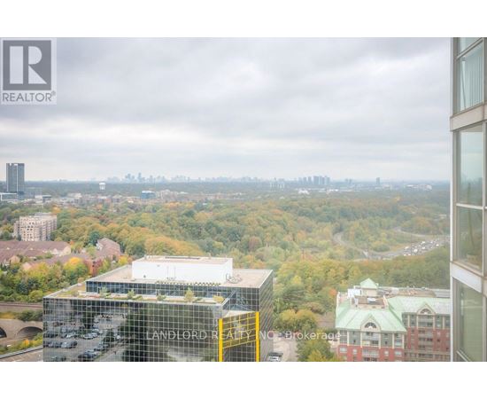 A view from a high-rise building looking out over a cityscape with a mix of residential and commercial buildings.