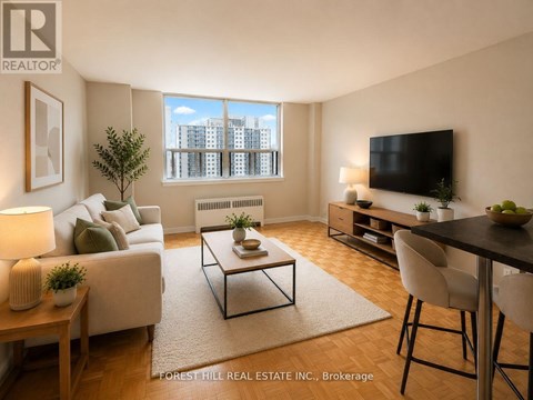 A living room with a couch, a coffee table, a television, and a window with a view of a cityscape.