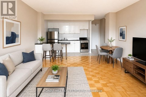 A well-lit, modern living room with a kitchen in the background.