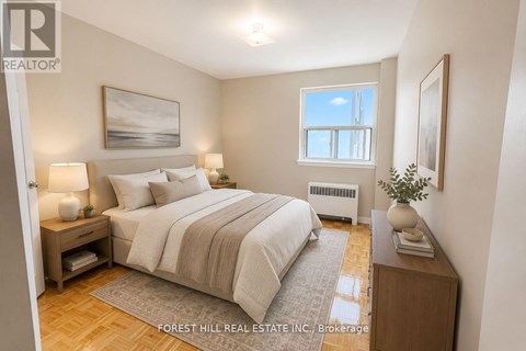 A bedroom with a large bed, a nightstand, and a window.