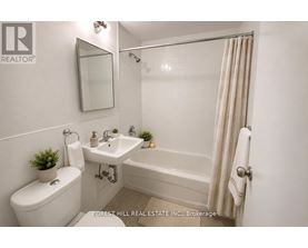 A white bathroom with a toilet, sink, and bathtub.