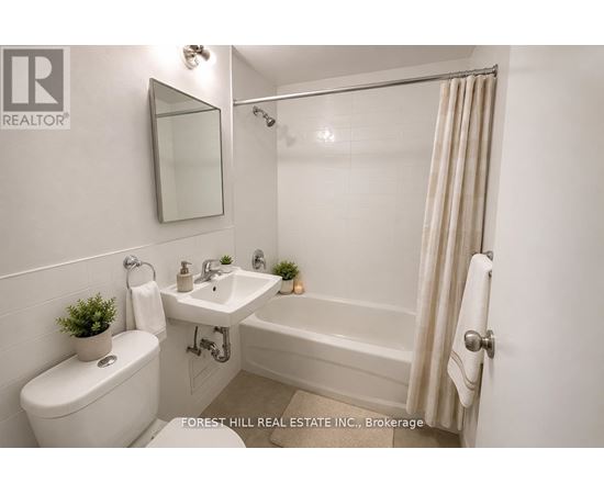 A white bathroom with a toilet, sink, and bathtub.
