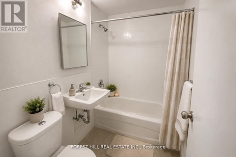 A white bathroom with a toilet, sink, and bathtub.