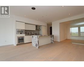 A modern kitchen with a marble island and wooden floors.