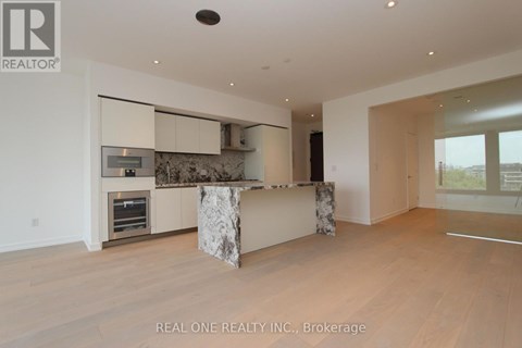 A modern kitchen with a marble island and wooden floors.