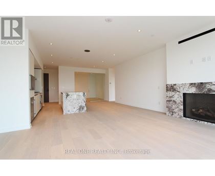 A spacious living room with a fireplace and a large painting on the wall.
