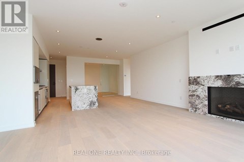 A spacious living room with a fireplace and a large painting on the wall.