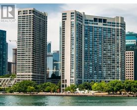 Two tall buildings stand next to a body of water.