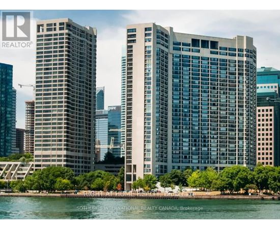 Two tall buildings stand next to a body of water.