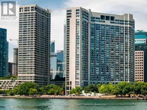 Two tall buildings stand next to a body of water.