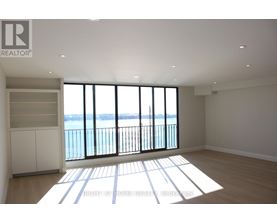 A spacious room with a view of the water through large windows.