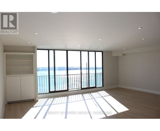 A spacious room with a view of the water through large windows.