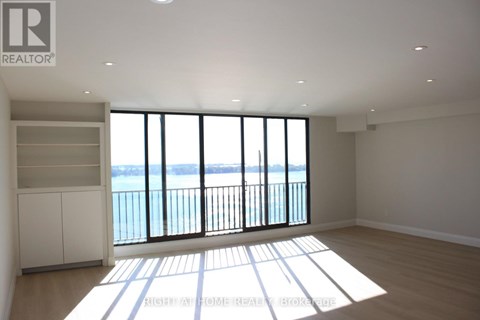 A spacious room with a view of the water through large windows.