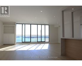 A spacious room with a view of the water through large windows.