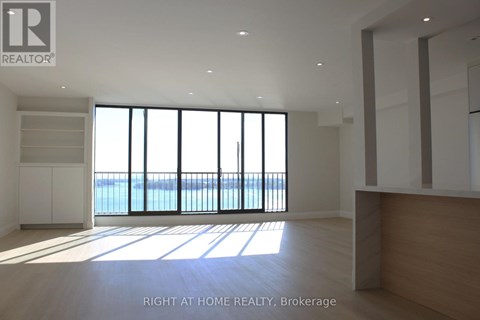 A spacious room with a view of the water through large windows.