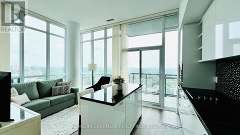 A modern living room with a glass table and a couch.