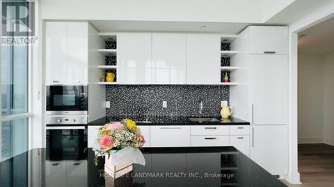 A modern kitchen with white cabinets and a black countertop.