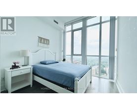A bedroom with a large bed and a view of the city.
