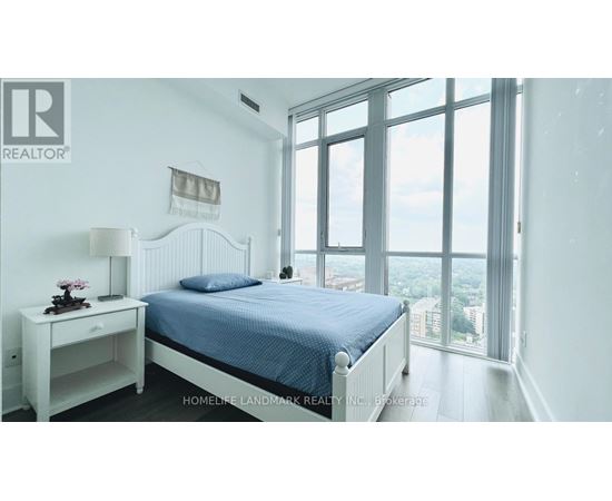A bedroom with a large bed and a view of the city.
