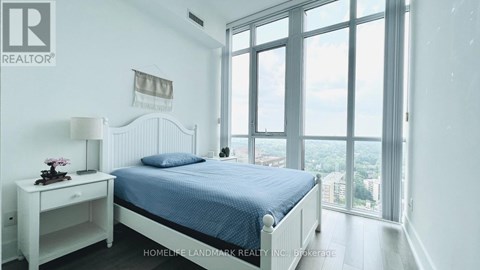 A bedroom with a large bed and a view of the city.