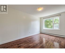 A room with a window and wooden flooring.