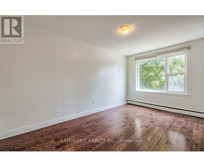 A room with a window and wooden flooring.