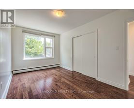 A room with a window and wooden flooring.