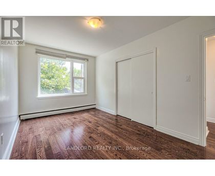 A room with a window and wooden flooring.