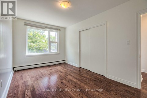 A room with a window and wooden flooring.