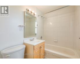 A white bathroom with a tub, sink and mirror.