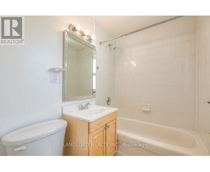 A white bathroom with a tub, sink and mirror.