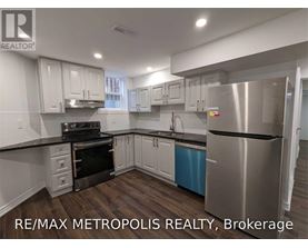 A modern kitchen with stainless steel appliances and white cabinets.