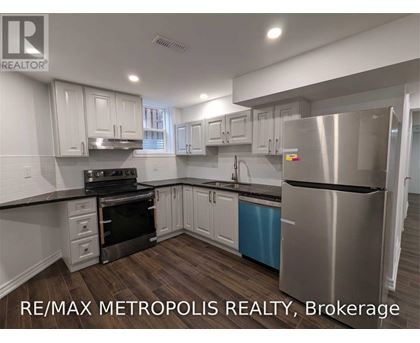 A modern kitchen with stainless steel appliances and white cabinets.