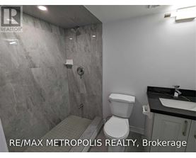 A bathroom with a toilet, sink, and shower.