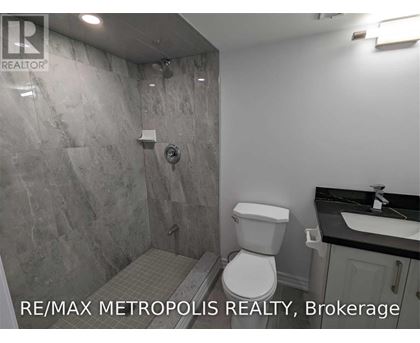 A bathroom with a toilet, sink, and shower.