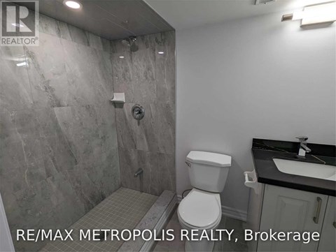 A bathroom with a toilet, sink, and shower.