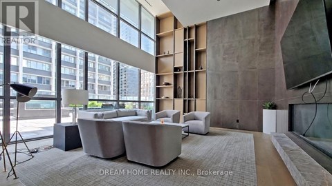 A modern living room with a large window and a grey sofa.