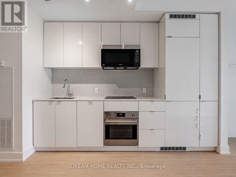 A modern kitchen with white cabinets and a stainless steel oven.