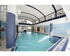 A swimming pool inside a building with a blue tiled column.