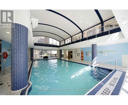 A swimming pool inside a building with a blue tiled column.